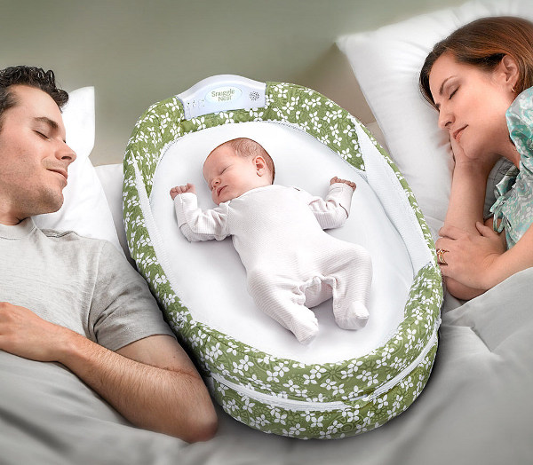 parents asleep with baby in snuggle nest surround
