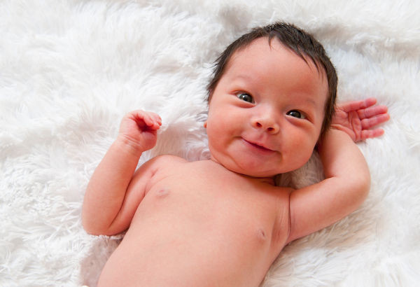 Happy newborn baby making a funny face