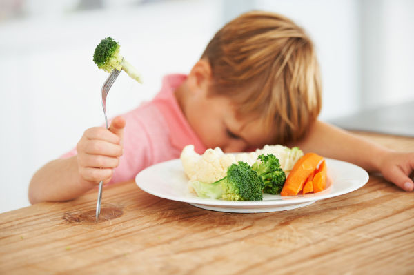Young boy eating vegetables