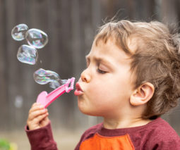 Toddler boy blowing bubbles - feature