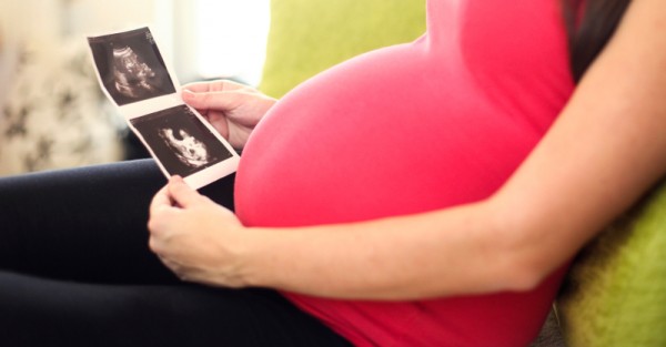 pregnant woman looking at ultrasound pictures