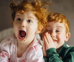 Redhead sister and brother laughing in pyjamas