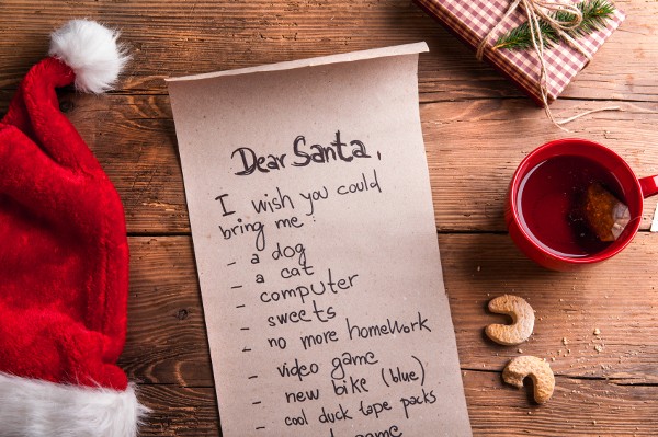 Wishlist for Santa Claus laid on a wooden table