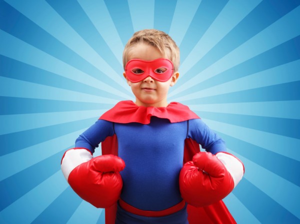 Superhero child with boxing gloves concept for childhood, imagination, aspirations and strength
