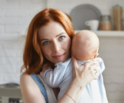 Redhead mother holding baby - feature
