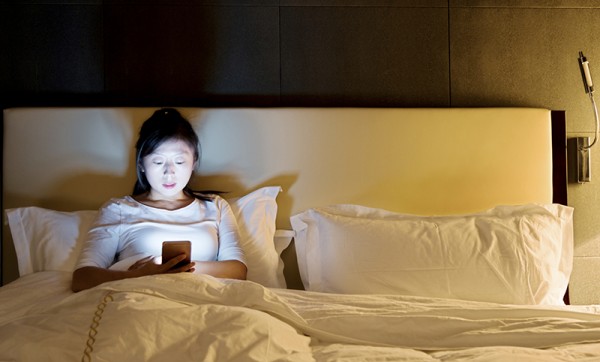 Woman using a smart phone in bed