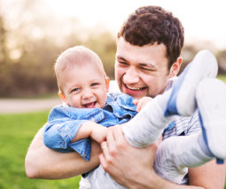 Father holding smiling boy in arms - feature