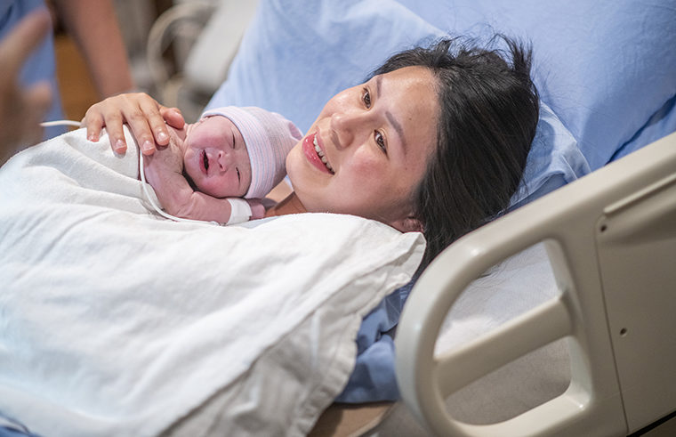 New mother in hospital bed with newborn baby - thumbnail