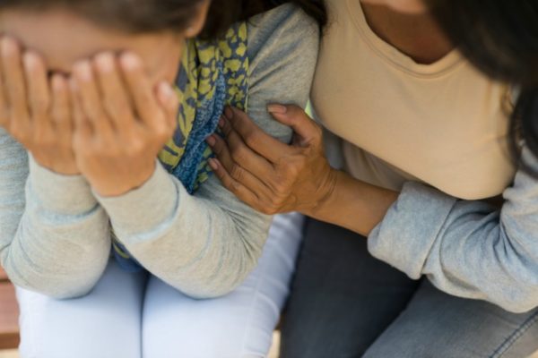 Woman comforting friend with postnatal depression
