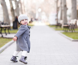 Toddler girl in park wearing beret and overcoat - feature