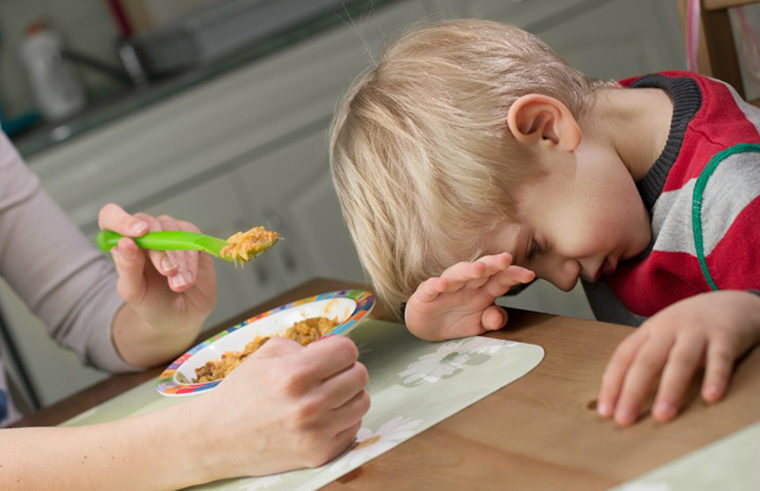 Young boy refusing dinner on spoon - feature