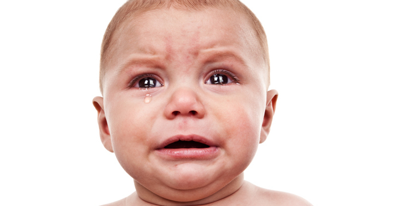 An 8 month old baby boy crying really big tears.