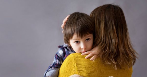 mother hugging a sad little boy