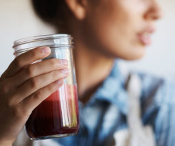 Woman drinking a red smoothie - feature