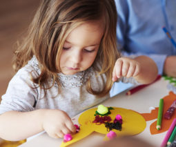 Young girl doing craft at a table - feature