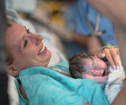 Mother holding newborn baby after birth in hospital - feature