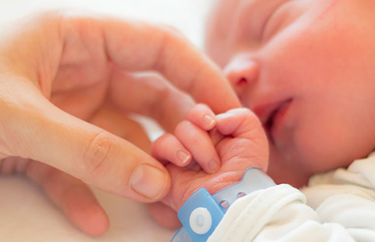 Newborn baby with hospital ID bracelet - feature