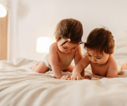 Twin baby girls on bed - feature
