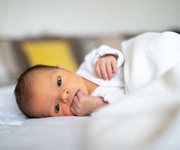 Newborn baby lying on side awake - feature