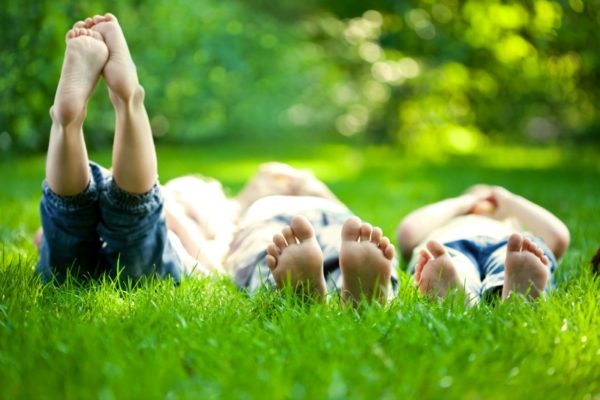 Three kids lying in grass 