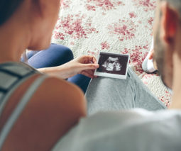 Couple holding ultrasound of baby - feature