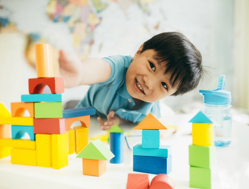 young boy playing with wooden blocks