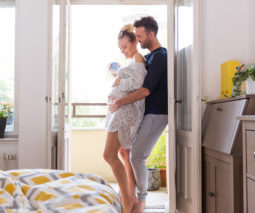 Pregnant couple embracing bedroom feature