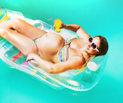 Pregnant woman floating in pool - feature
