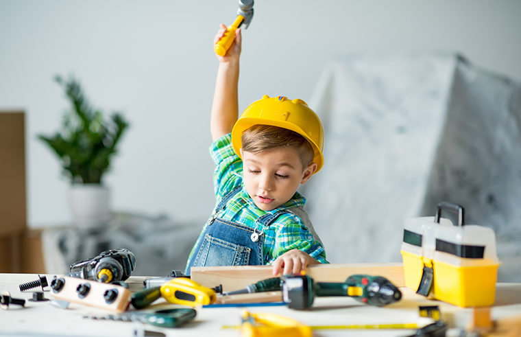 Preschool boy playing with tools and building - feature