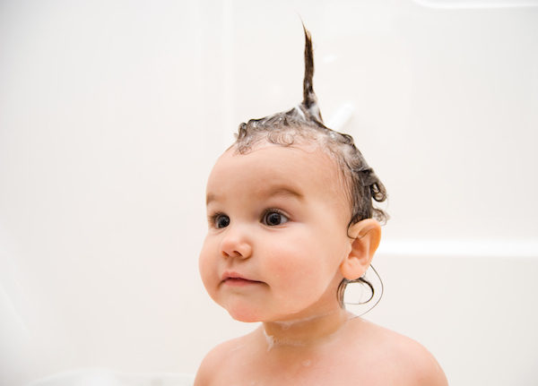 Baby in bath with bubbles in hair