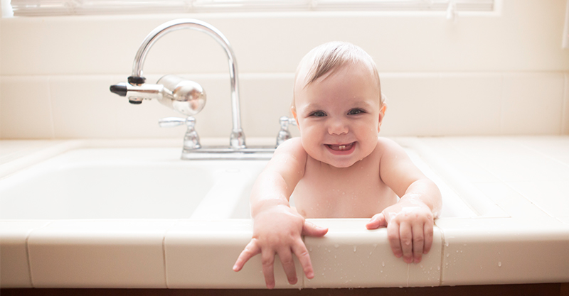 smiling baby sitting in bath