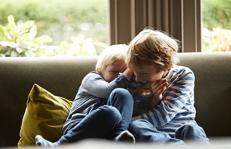 Two boys playing on couch - feature