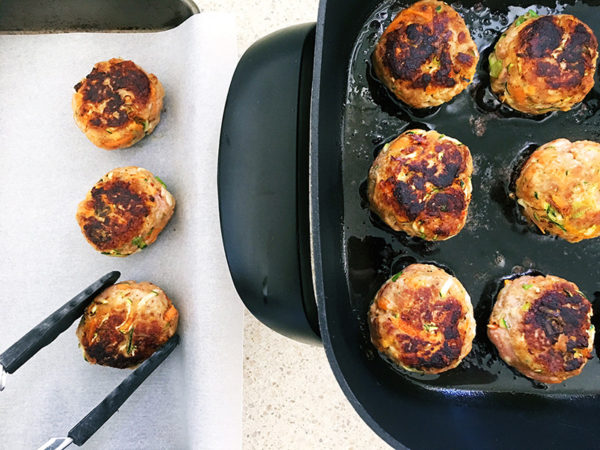 turkey and vegetable rissoles frying in a pan