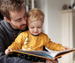 Father reading a book with toddler baby - feature