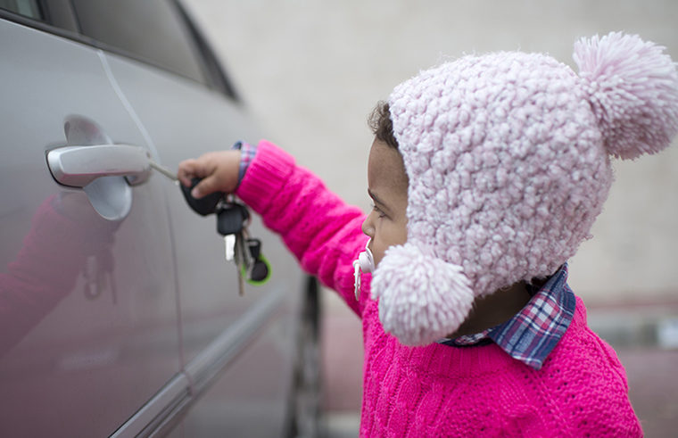 Toddler holding keys opening car door 