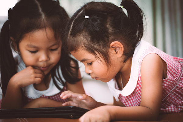 Two girls playing with tablet