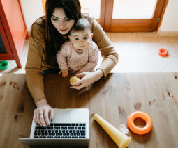 Mother on computer with baby on her lap - feature