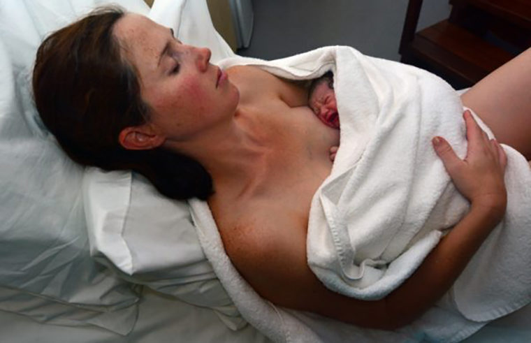 Woman holding baby after birth - feature