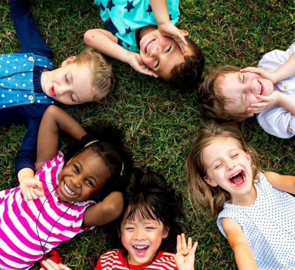 Kids lying on the grass smiling