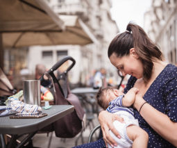 Mother breastfeeding baby in outdoor cafe - feature