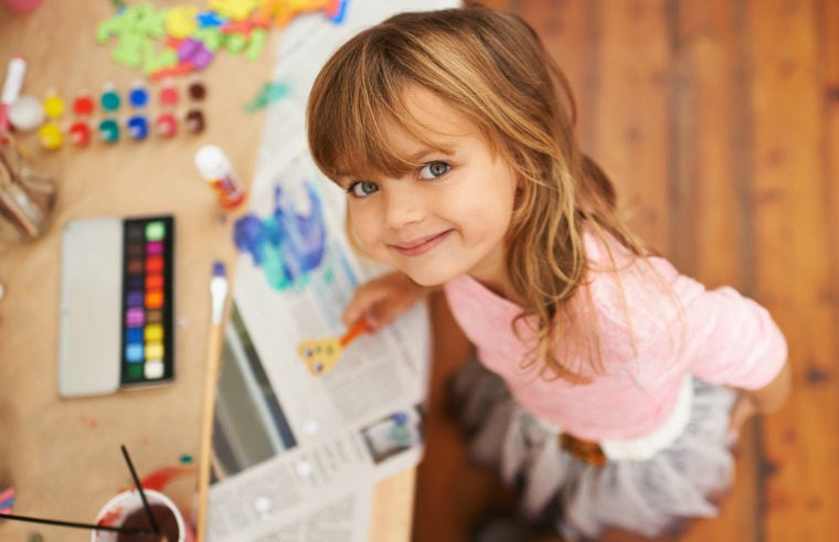 Happy preschool girl painting