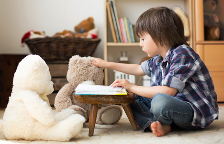 boy reading to teddy bears - feature