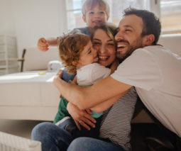 Family with two kids hugging - feature