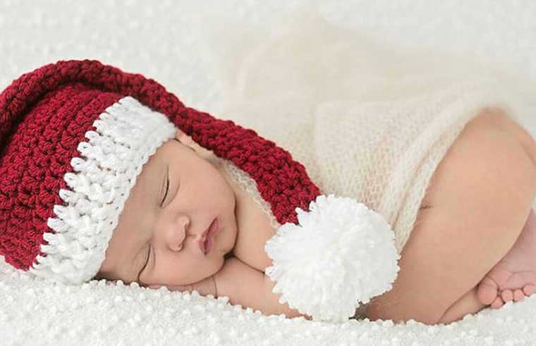 Sleeping baby in knitted Santa hat