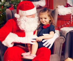 Girl sitting in Santa's lap for Christmas - feature