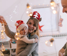 Mother and father with baby and Christmas lights - feature