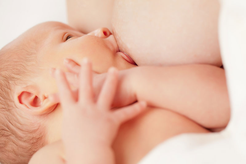 Breastfeeding baby looking at mum