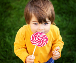 Toddler boy eating lollipop - feature