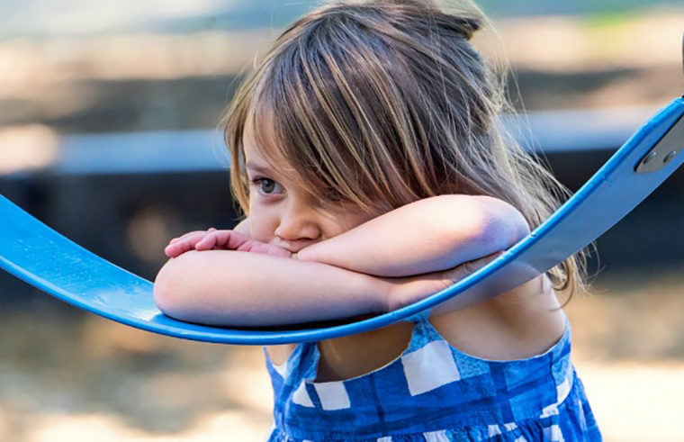 Little girl upset on swings - feature