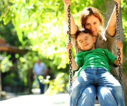 Mother and son on swing at park - feature